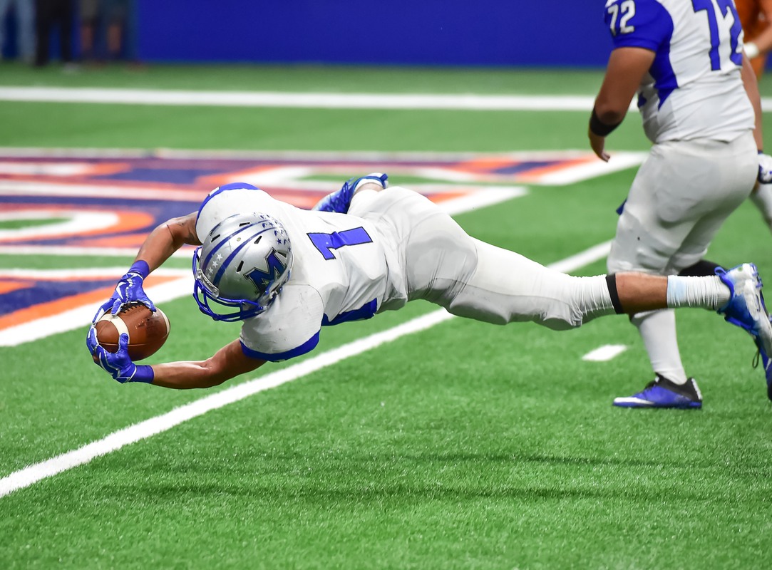 A professional football player dives for the end zone while holding a football, dressed in a helmet and other typical gear. There's a complex relationship with CBD in professional sports, thanks to complex and changing regulations around all forms of cannabis.